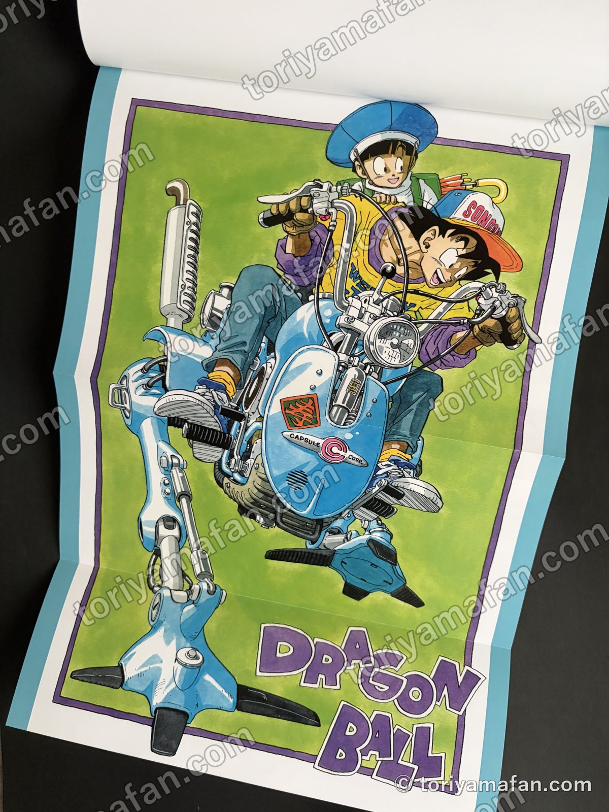 とじ込みの特製ポスターを広げたところ。悟空と悟飯が脚の付いたバイクに乗っている絵