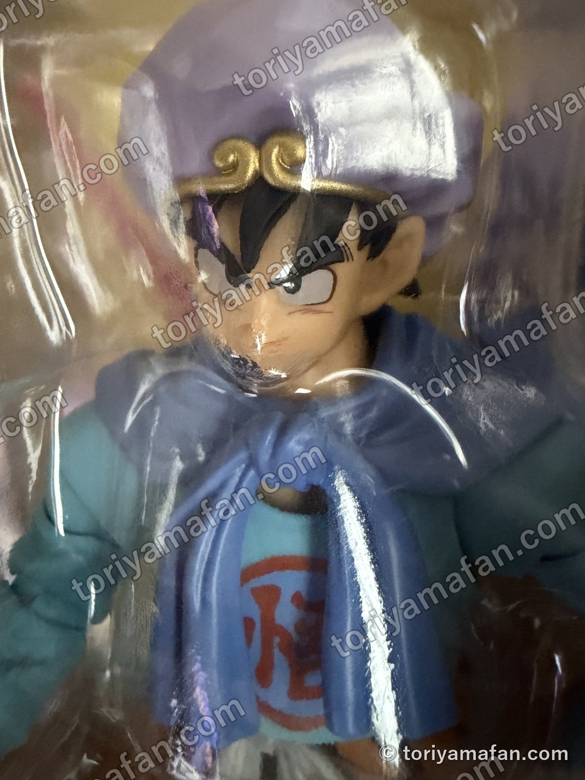 外箱の窓から見たフィギュアの顔。紫のターバンに金の輪、青いスカーフ